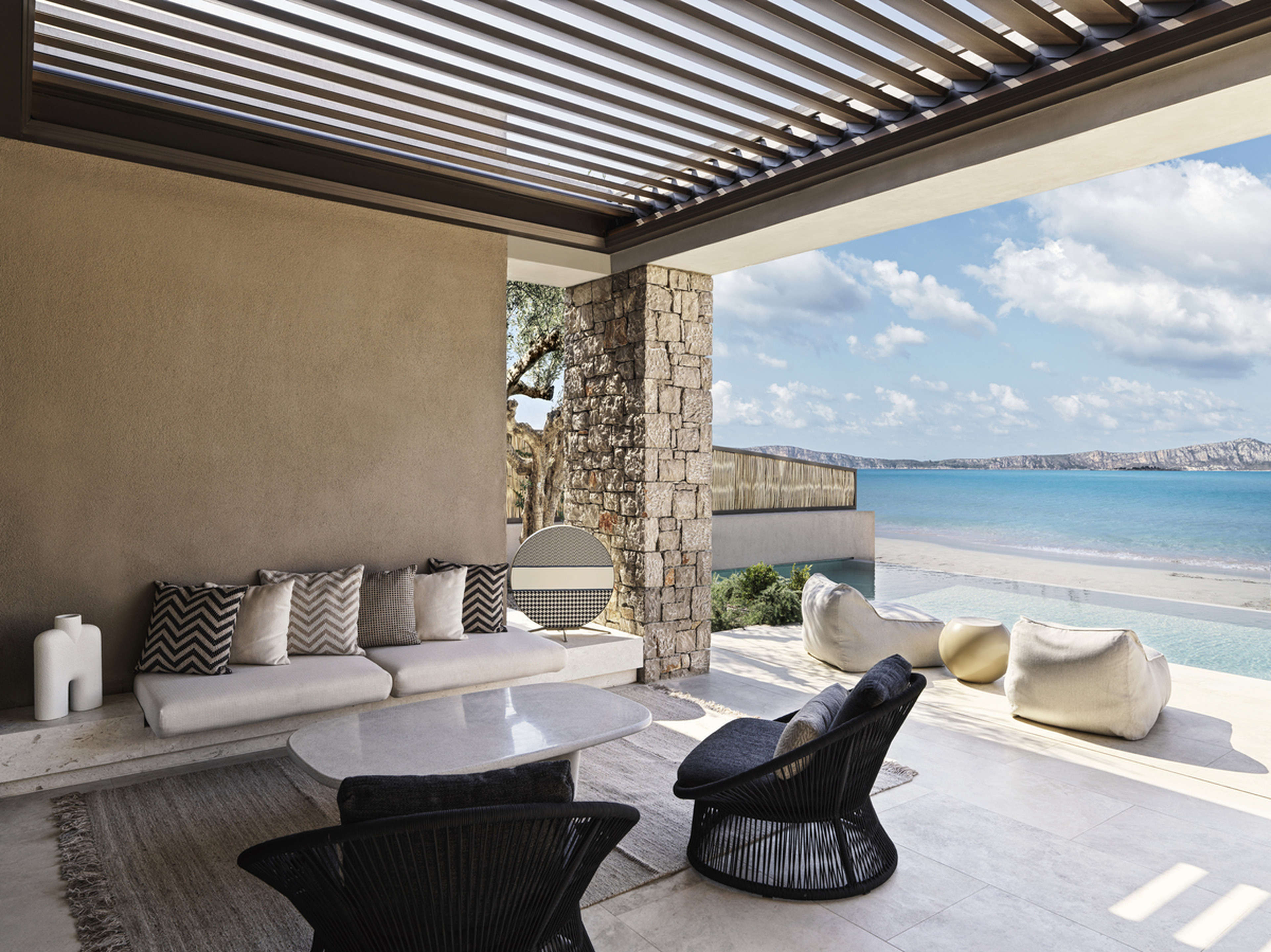 A seating area and pool by the beach at W Costa Navarino