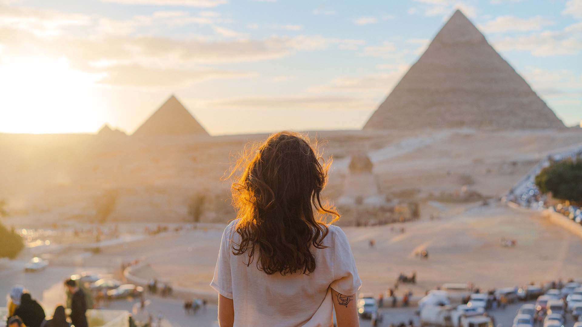 A woman tourist looks towards the Great Pyramids in Cairo, Egypt