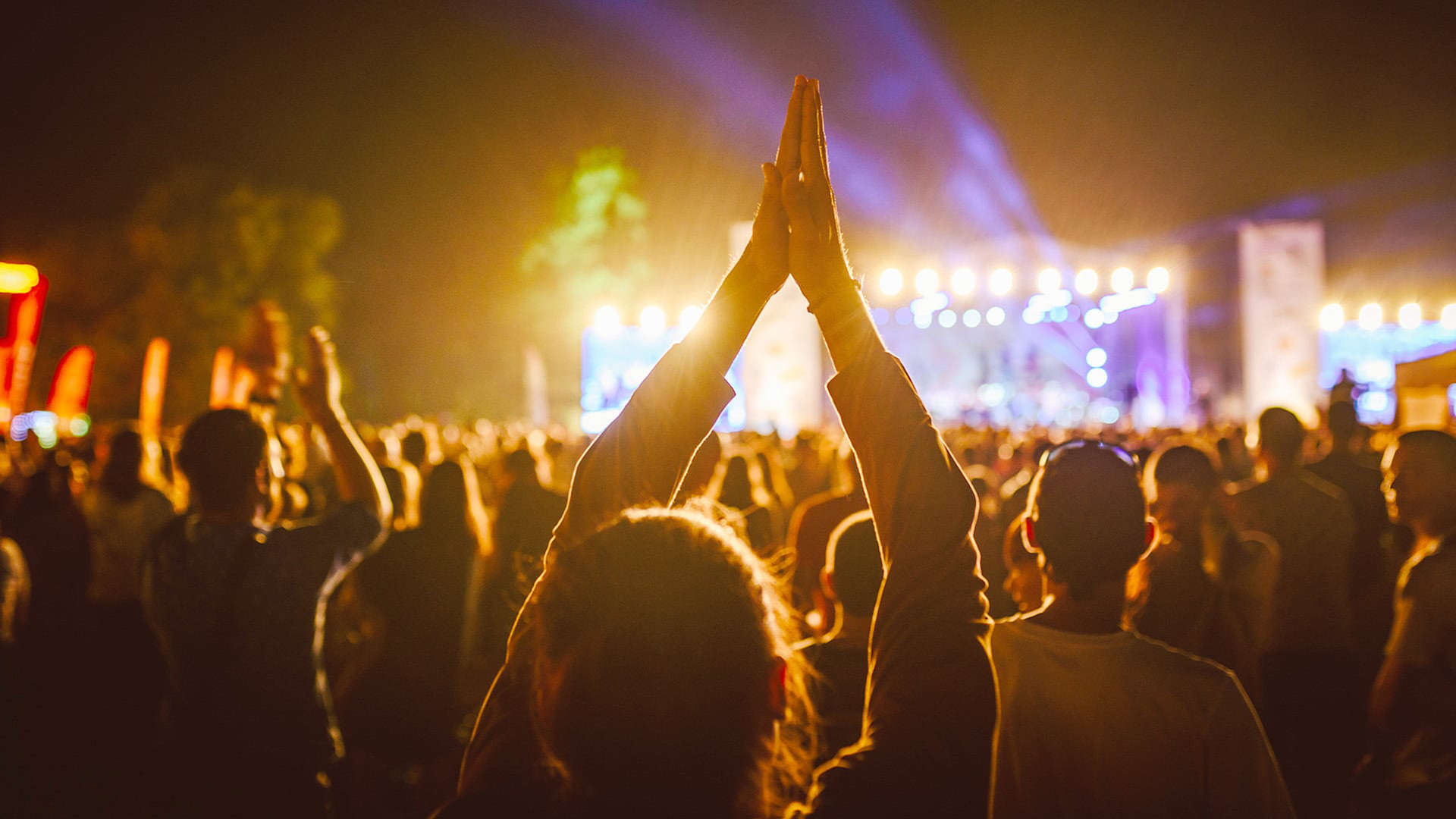 Menschenmenge wirft beim Musikfestival die Hände in die Luft