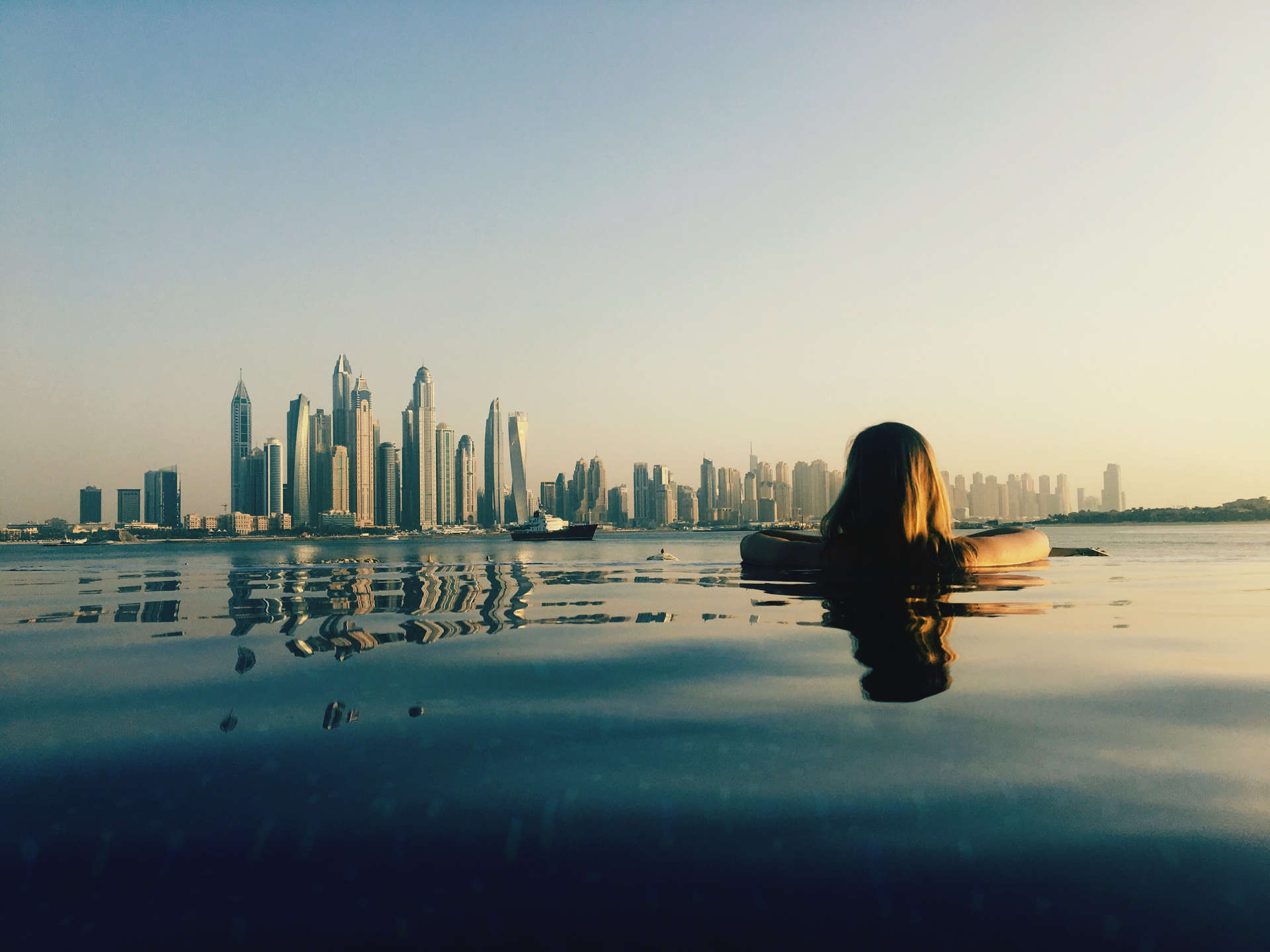 Donna che ammira Dubai mentre nuota in piscina