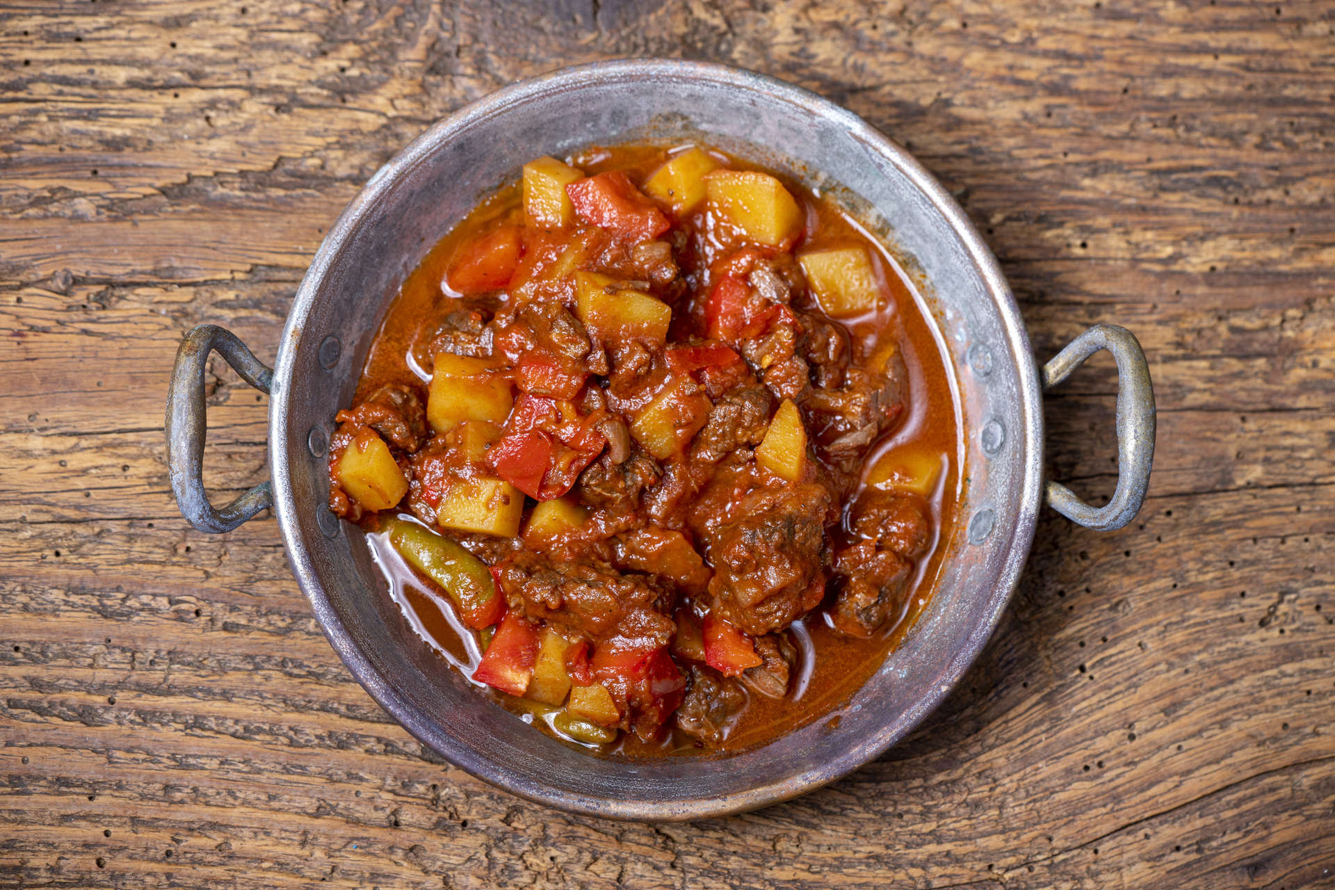 Gulasch, un denso stufato di manzo, patate e verdure condito con paprika e altre spezie.