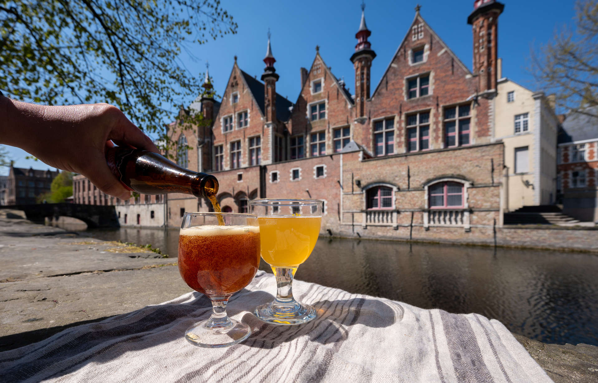 Tasting of Belgian beer with view on medieval houses and canals in Belgium