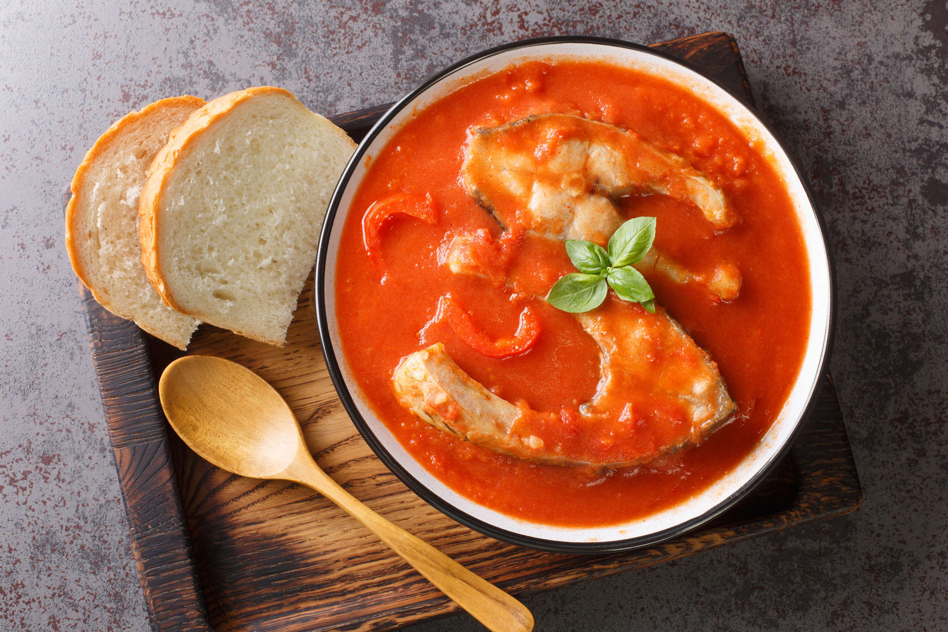 Thick hearty Soup with carp steak, vegetables and paprika close-up in a bowl