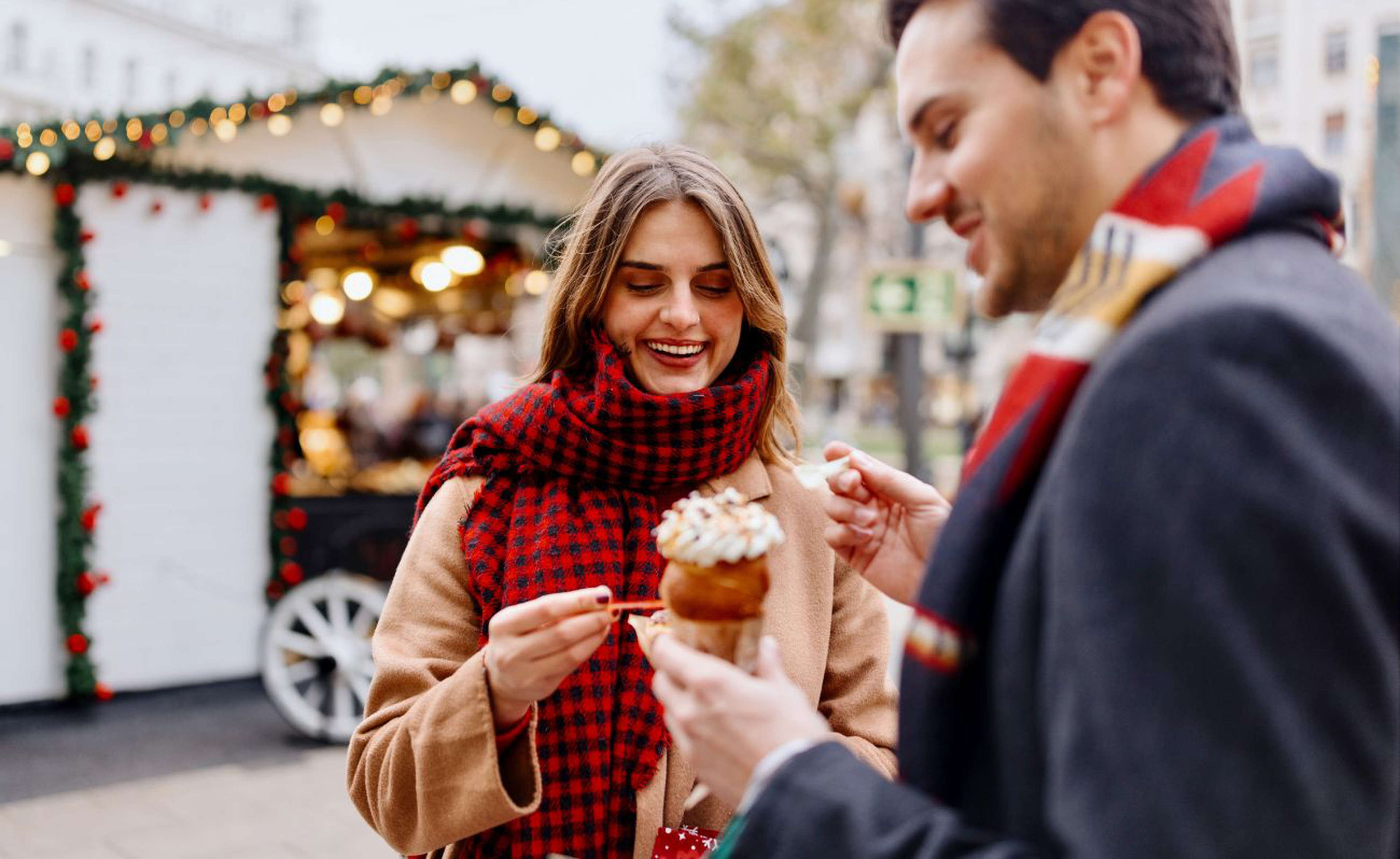 Un jeune couple déguste des friandises sur un marché de Noël hongrois (Photo : Getty Images) ​