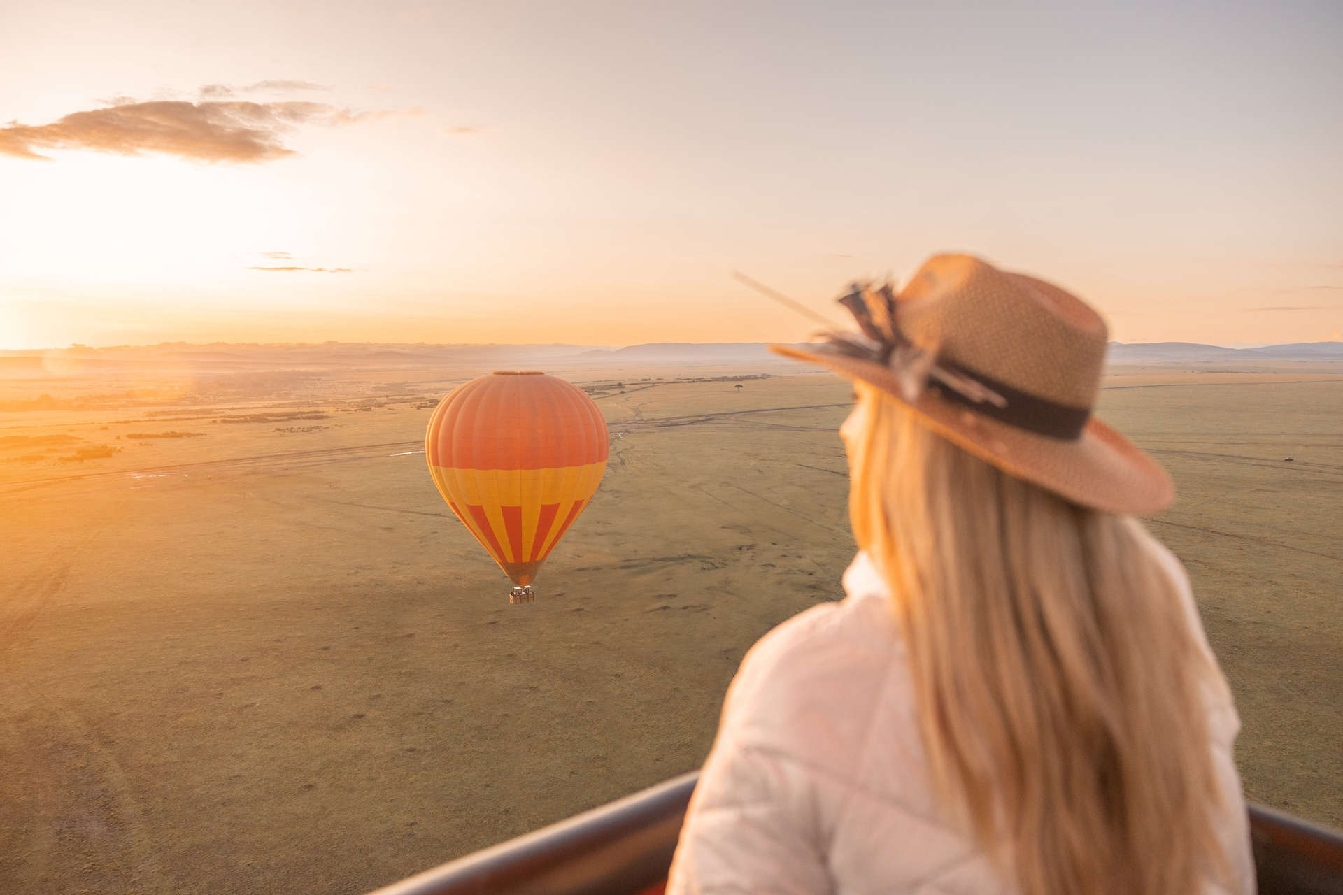 Woman in hot air balloon above African savannah