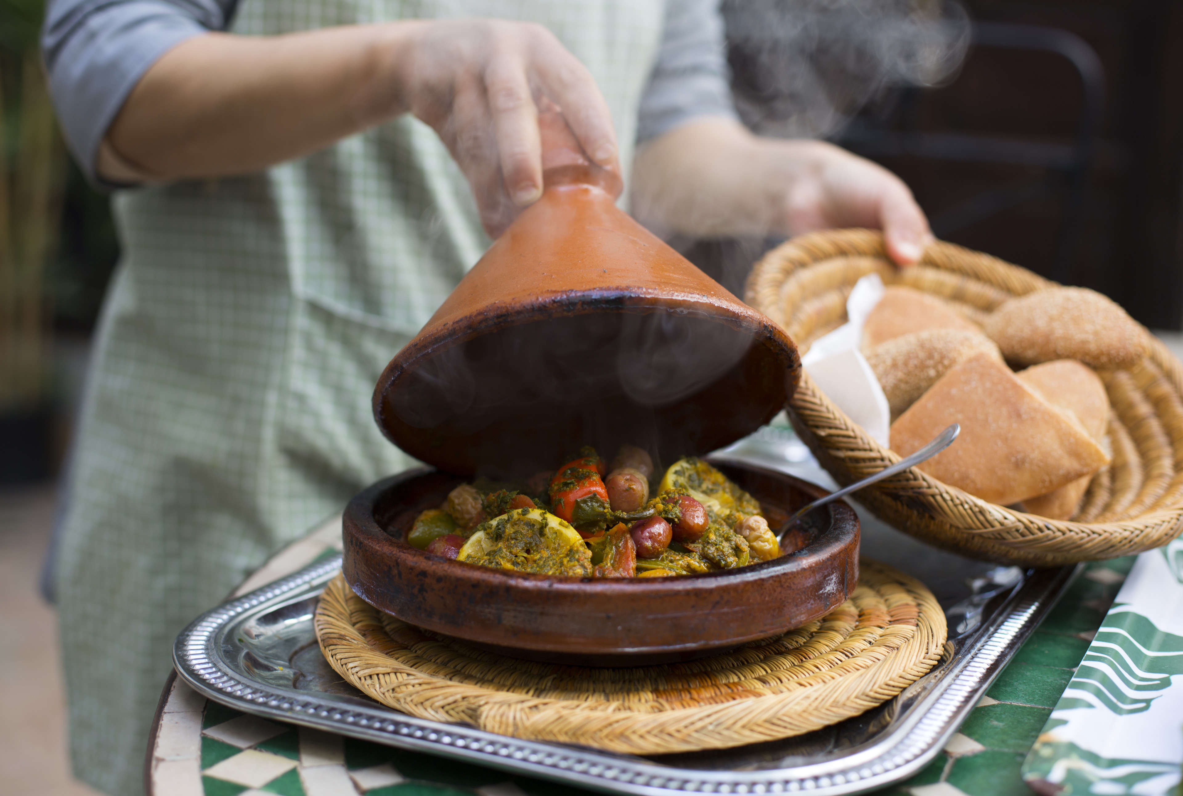 Woman lifting lid of tajine