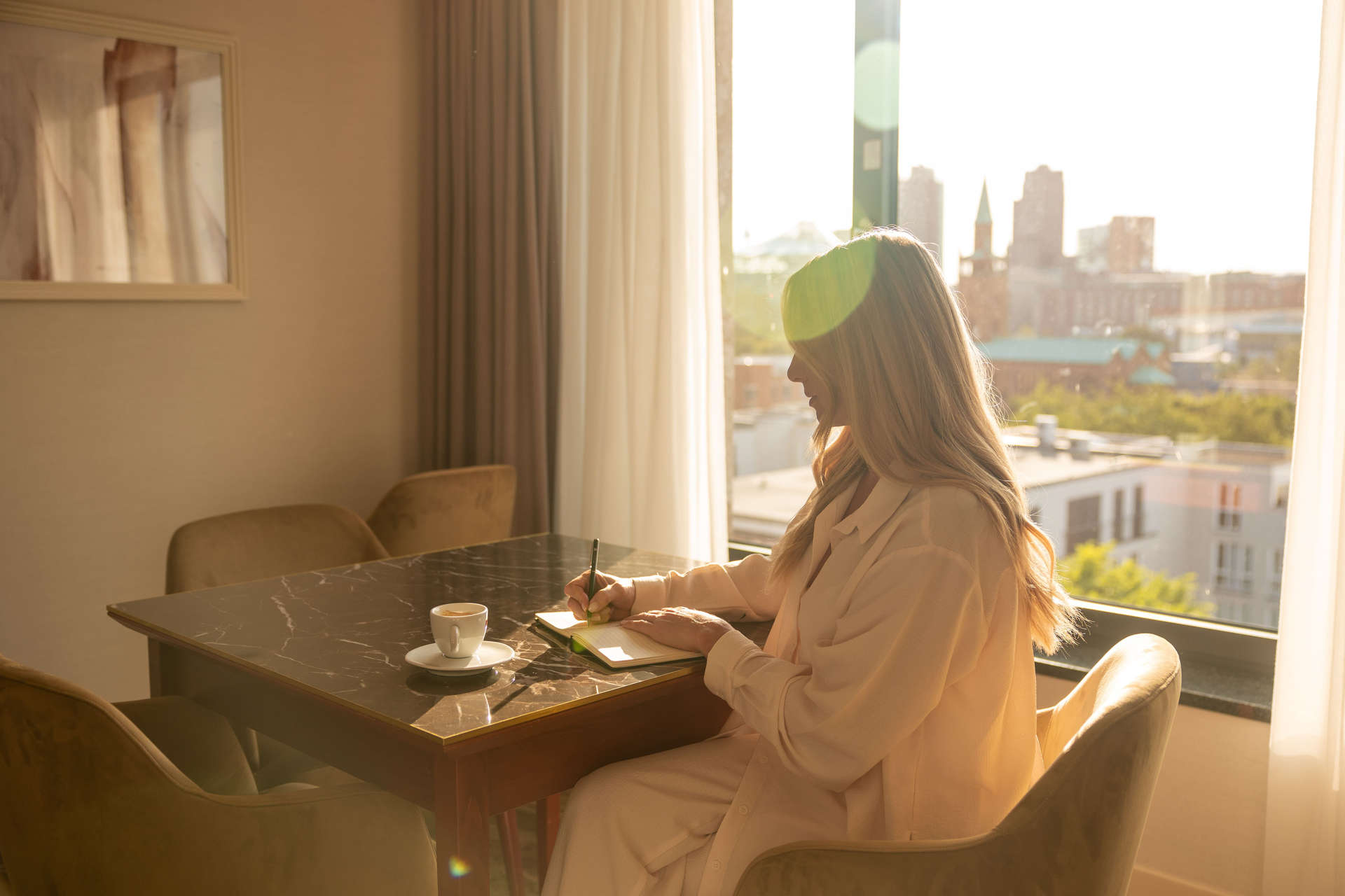 Woman writes in her journal in her guest suite at the JW Marriott Berlin