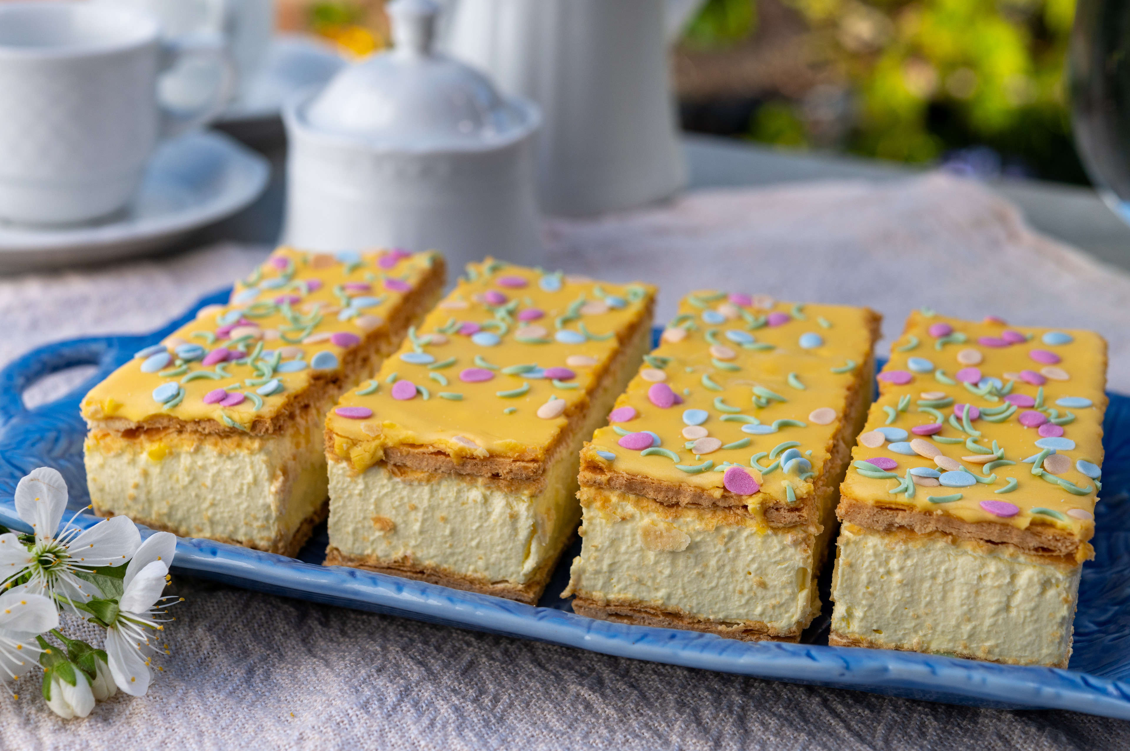 Tompouce features a good dose of cream piped between two rectangular pieces of puff pastry, with the top slice finished with pink icing.