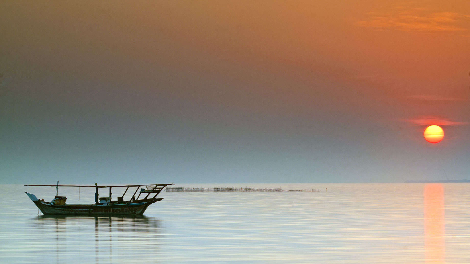 Einsames Boot im Sonnenaufgang bei Al-Hidd